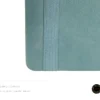 Light blue leather-covered notebook with rounded corners, matching elastic band, and pen loop, paired with an illustrated blue and yellow fountain pen and a floral 'joie' logo.