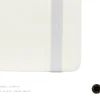 White A5 faux leather dot grid notebook with white elastic band, pen loop, Joie floral logo, and illustrated fountain pen